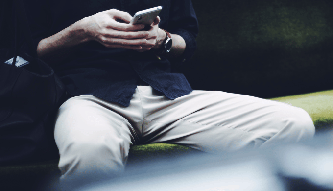 スマホを眺め指が止まる男性のイメージ写真