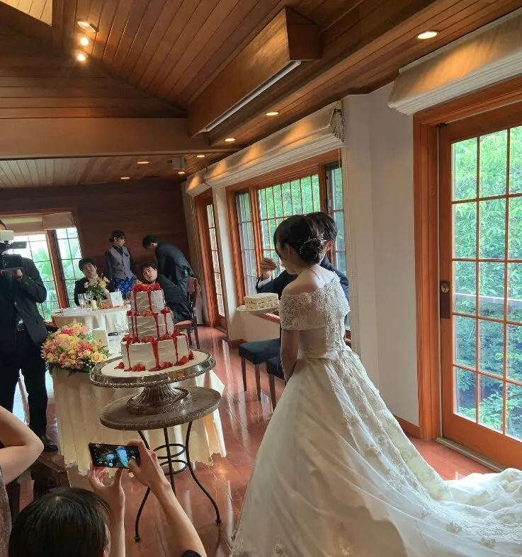 真心マッチ編集部「タナカマミ」の結婚式の写真。ウェディングドレス姿でケーキカットを行う披露宴の様子（実写）