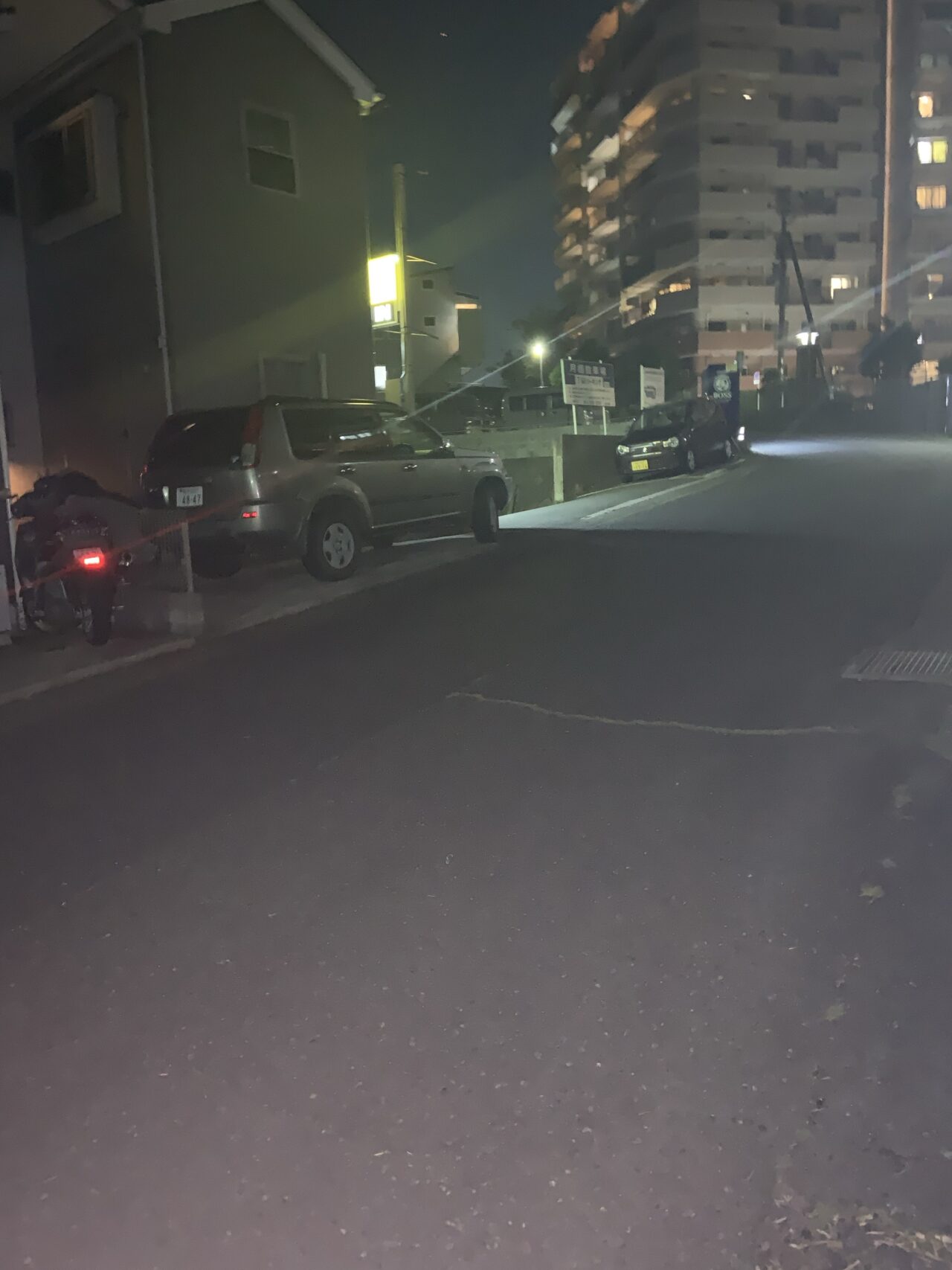 T字路を左に曲がると見えてくる夜のパーキングエリアと篠塚八幡社へと続く階段前の風景