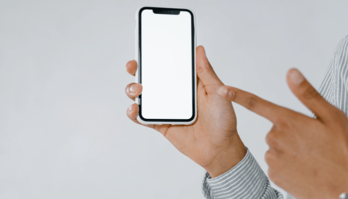 スマートフォンを指さす手元のイメージ